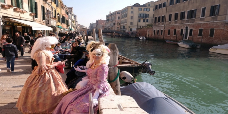 Mulheres mascaradas e com vestidos de época ao lado de canal em Veneza neste sábado — Foto: Manuel Silvestri/Reuters