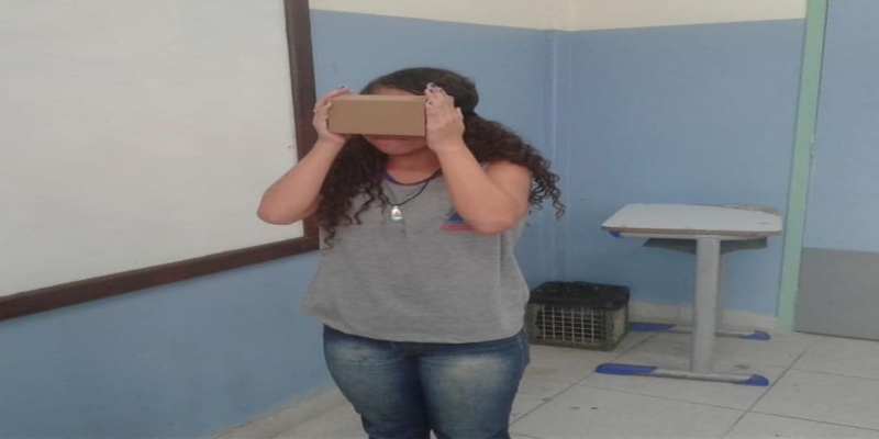 Realidade virtual pode ser visualizada por meio de um óculos, que é instalada em uma caixa de papelão — Foto: Divulgação/Seeduc